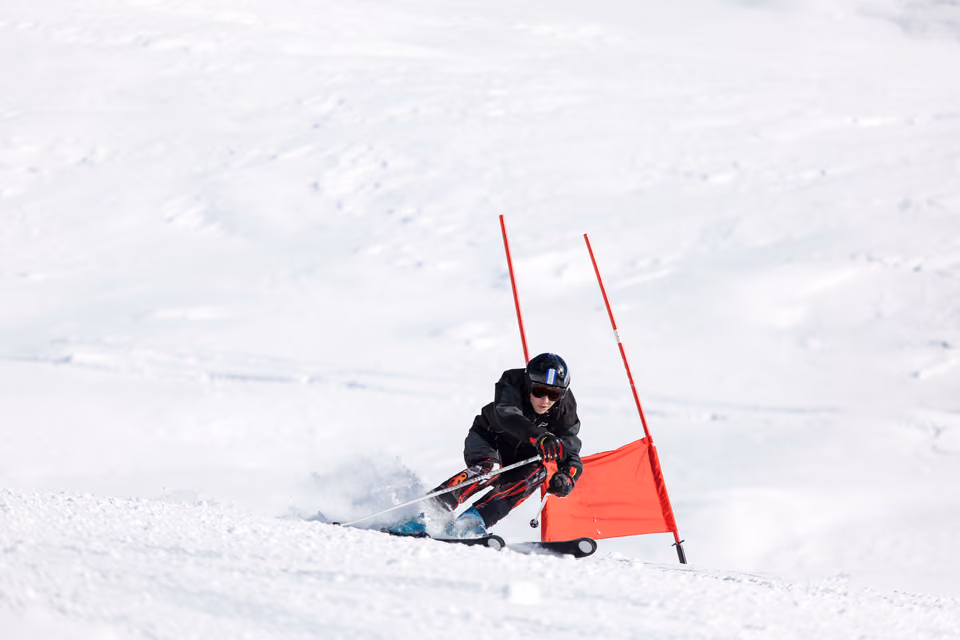Skirennläufer durchfährt ein Tor auf der Piste